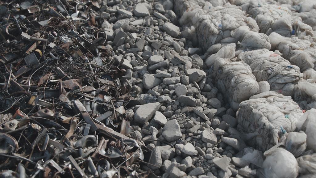 Rottami metallici, macerie inerti e rifiuti misti accatastati in un'area di stoccaggio per la classificazione CER